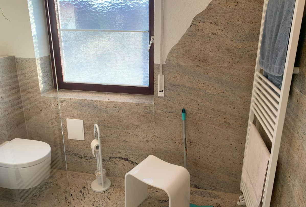 Ausschnitt aus einem Badezimmer mit Granitfliesen als Bodenbelag und Wandbelag